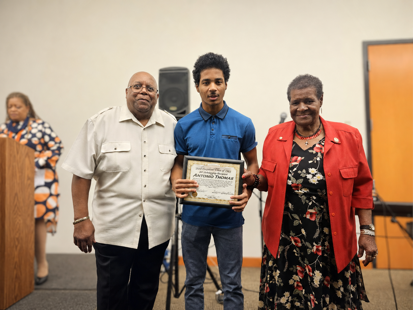 Antonio Thomas receiving a framed scholarship award certificate from two branch members