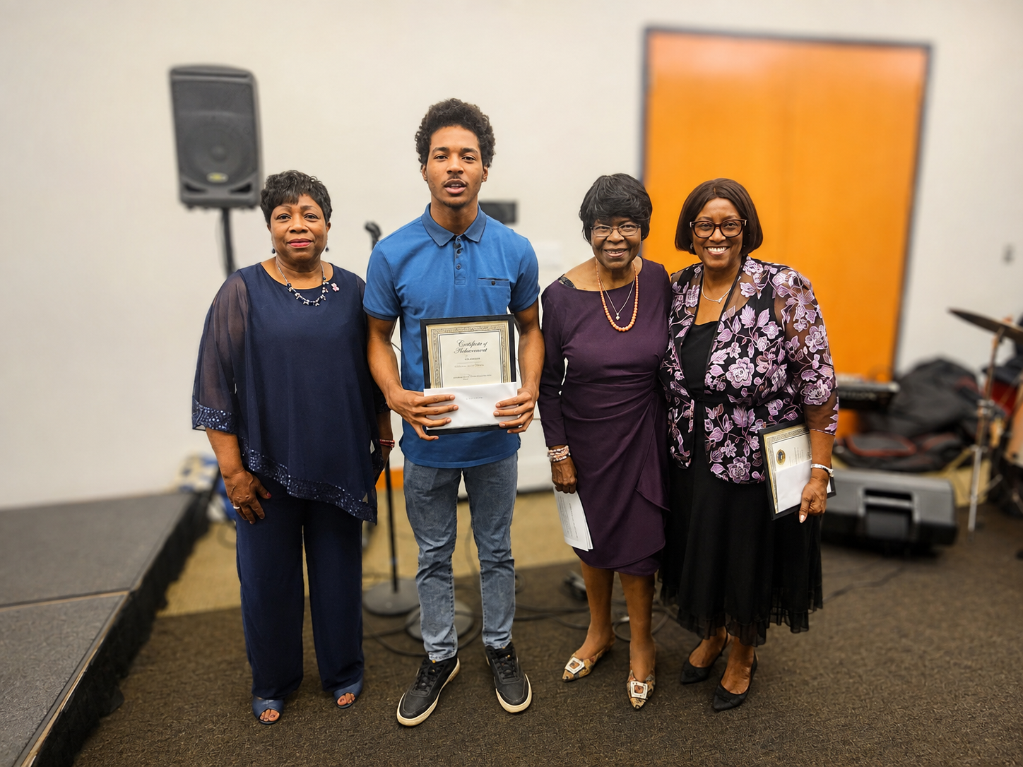 A student receiving a certificate of achievement with three branch members