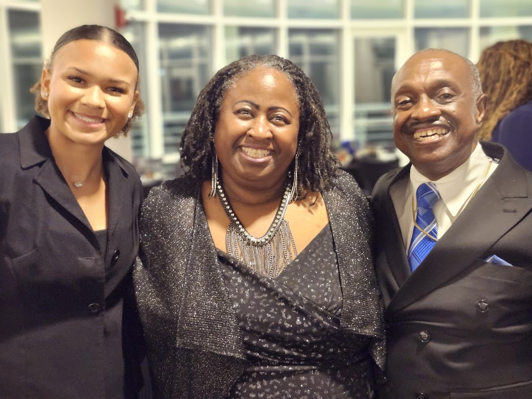 Three guests smiling together at the Scholarship & Awards Banquet