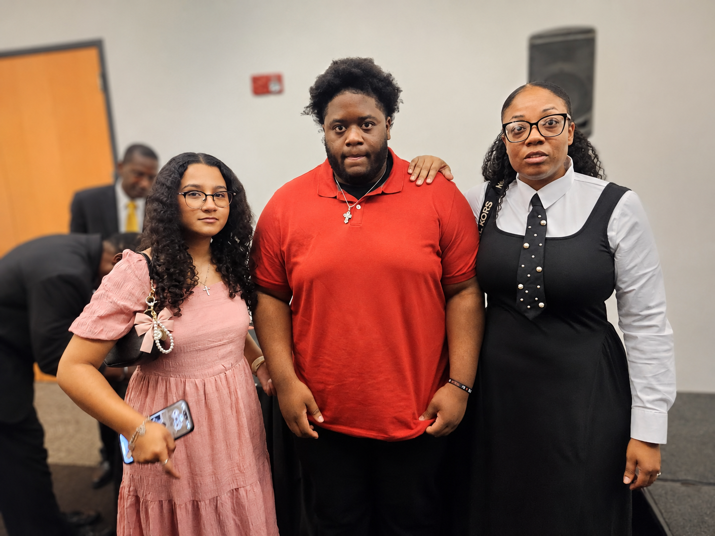 Three attendees posing together for a group portrait at the banquet
