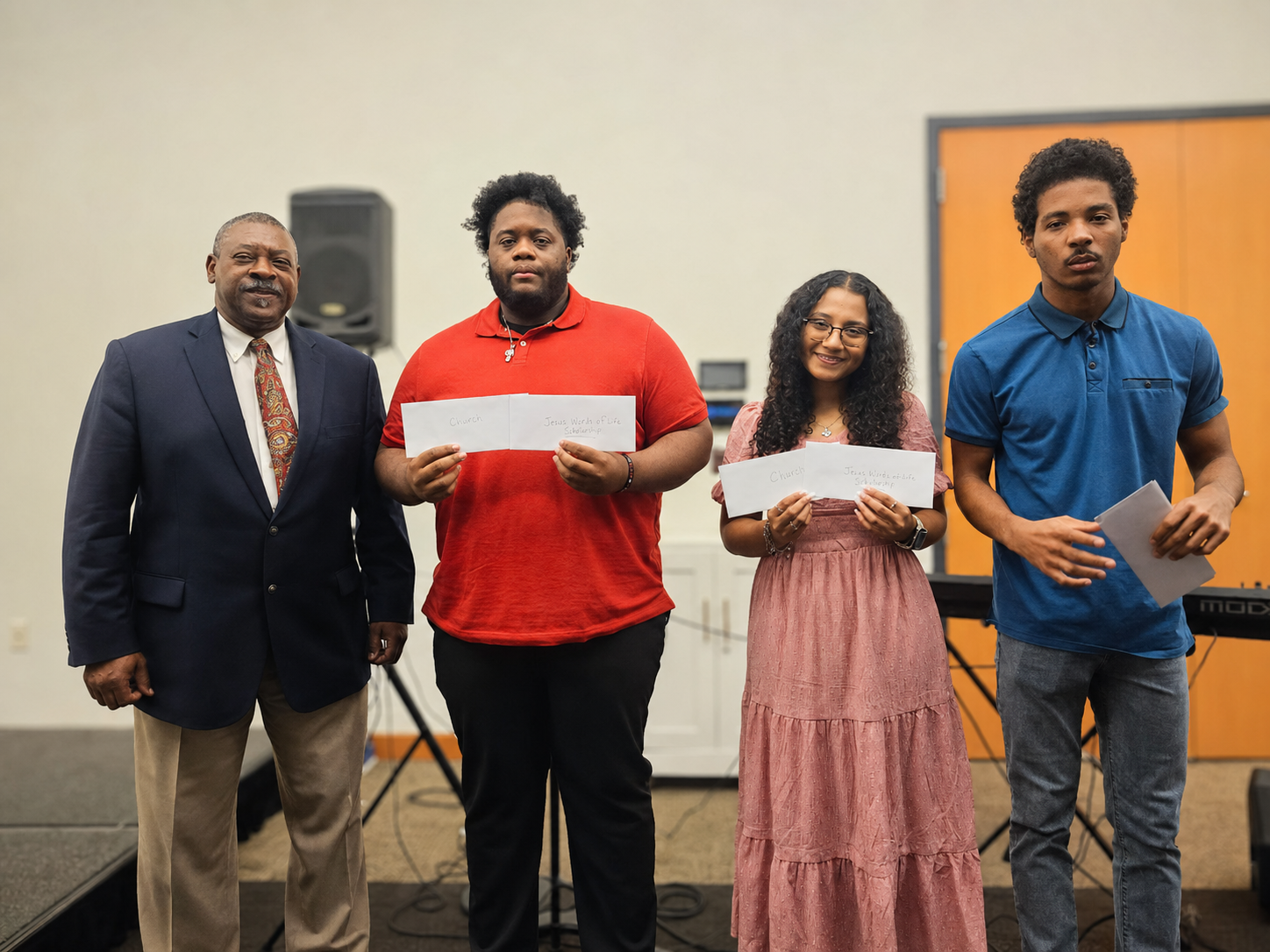 Award recipients holding scholarship certificates on stage