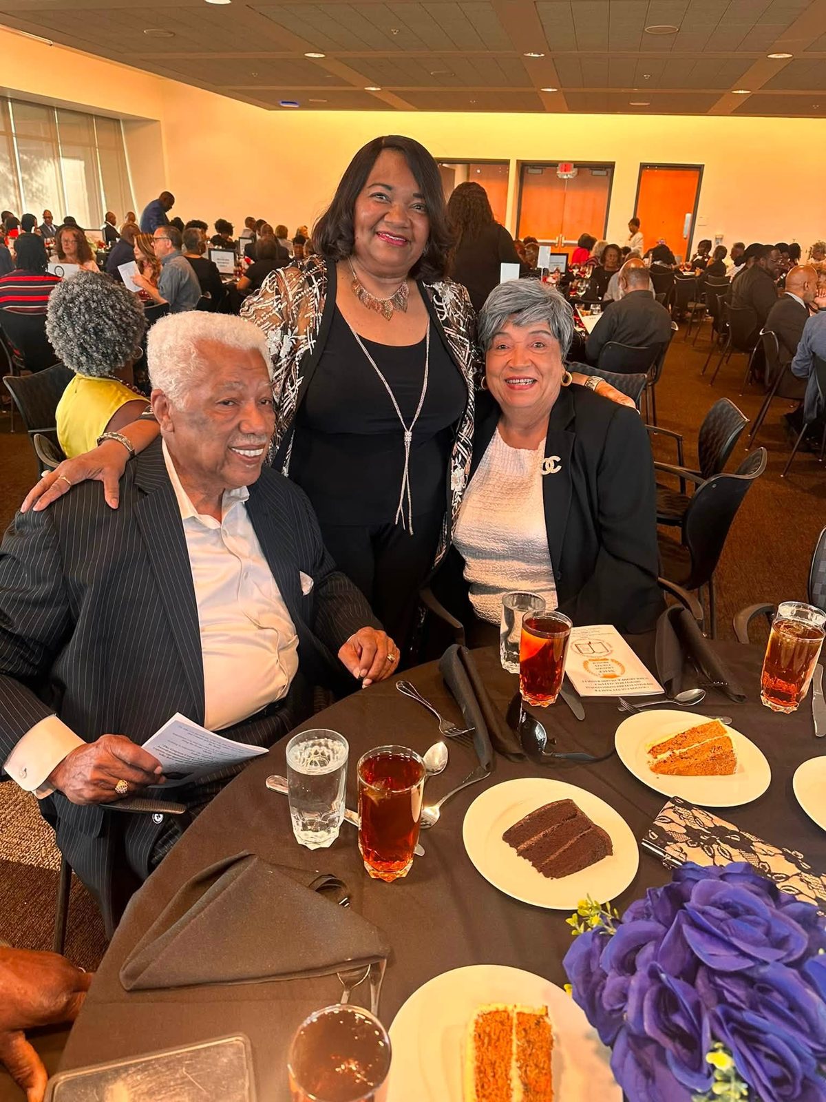 Three guests standing together for a photo at the banquet
